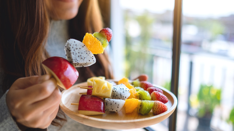 Woman eating tropical fruit