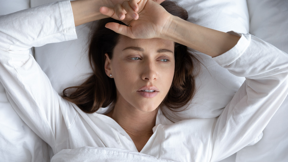 Woman lying in bed looking sad