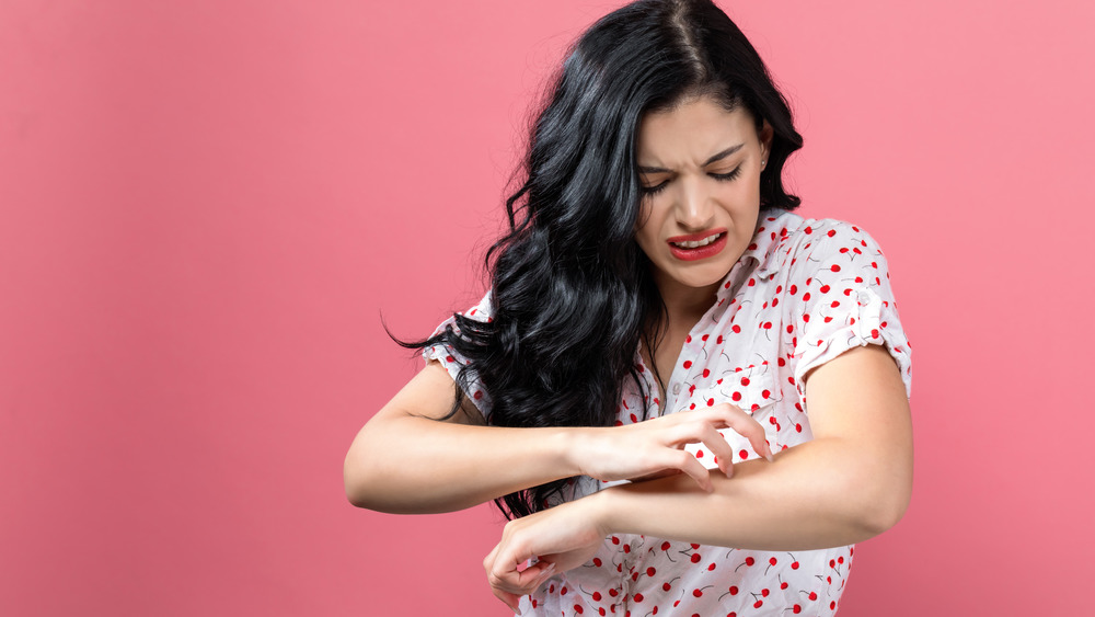 Woman scratching her arm