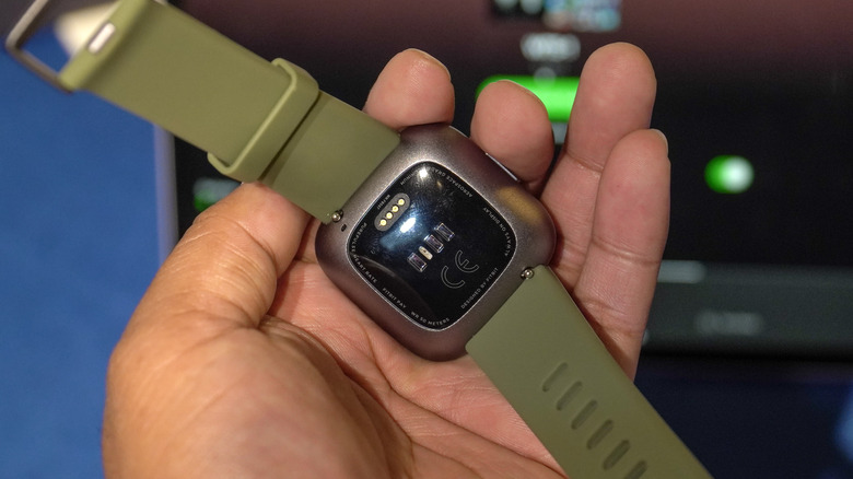 Hand Holding Fitbit Versa 2