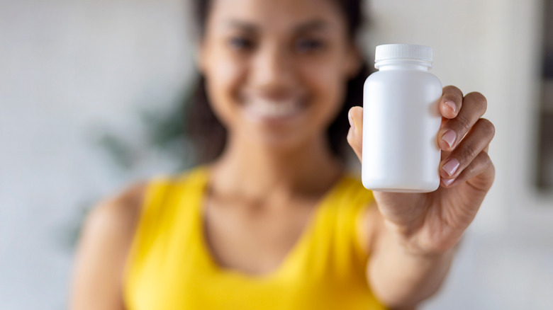 Woman holding pill bottle