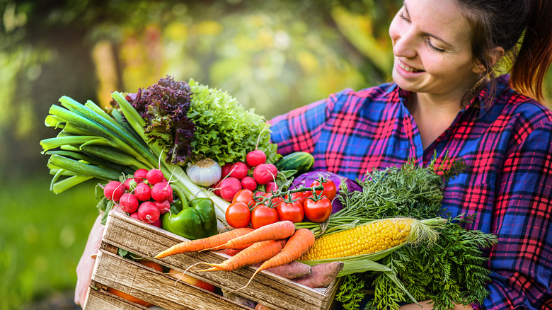 woman holding a basket of fruit and vegetables