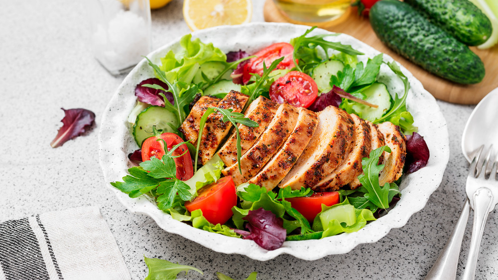 Salad in a bowl with grilled chicken on top