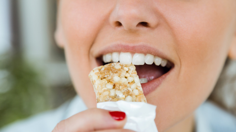 Woman eating protein bar 