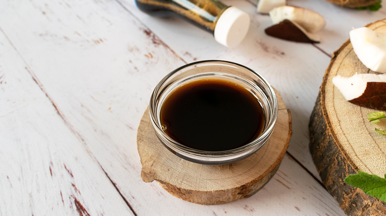 Glass bowl with brown liquid on wood 