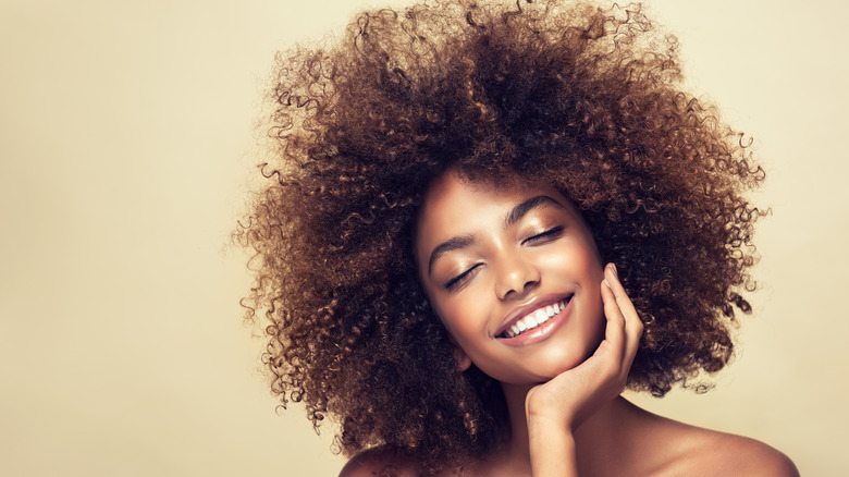 A smiling woman with naturally curly hair