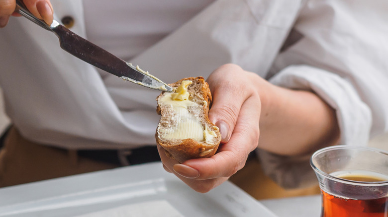 Woman spreading margarine on bread