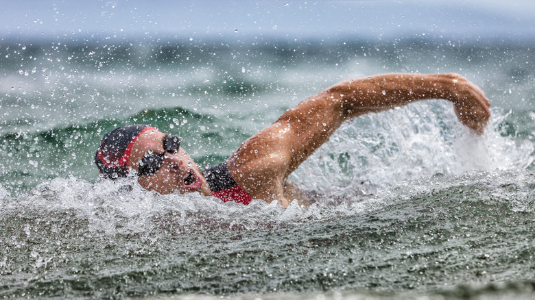 Swimmer in cap and goggles cutting waves