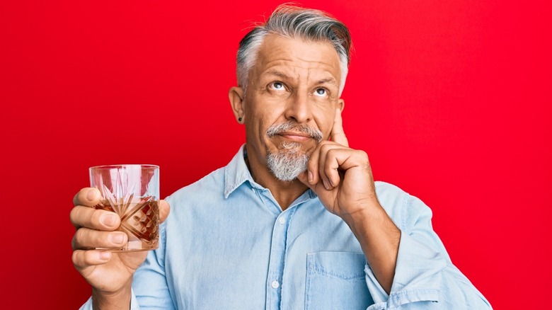 man holding glass of alcohol