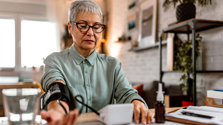 A woman measures her blood pressure at home
