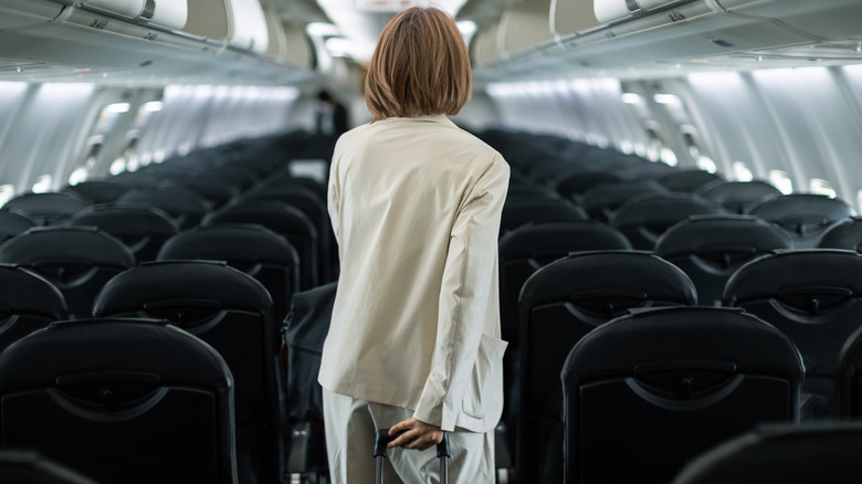 woman walking down the aisle of the plane