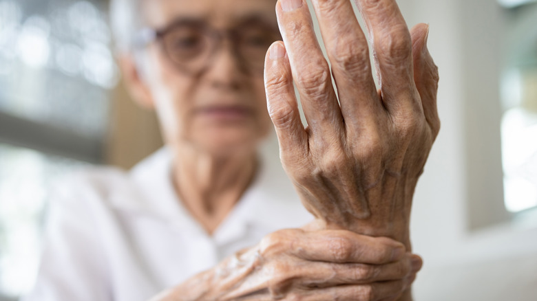 elderly asian woman with wrist arthritis 