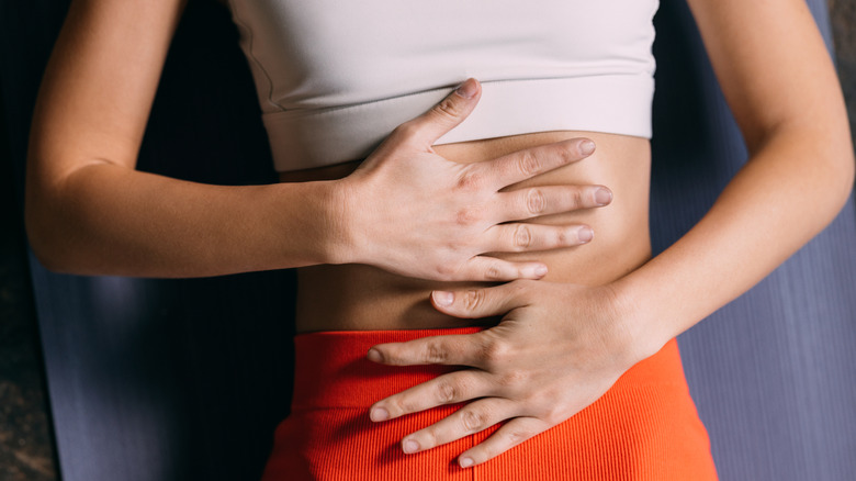woman lying on her back with hands on stomach
