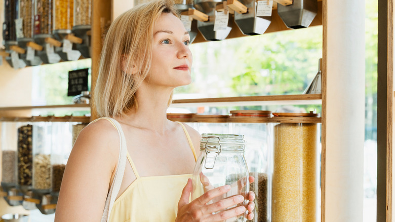 A woman checking out assorted grains at a store