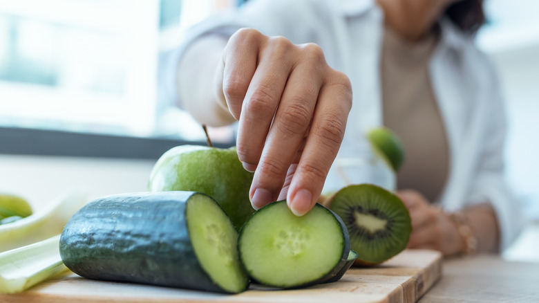 Hand picking up cucumber slice