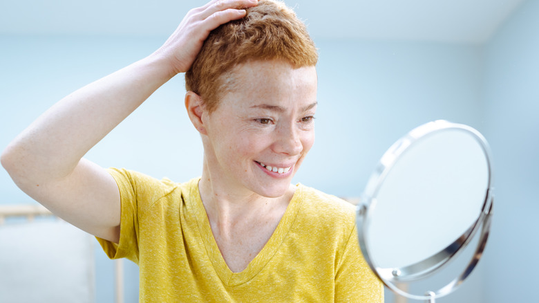 Woman smiling at makeup mirror