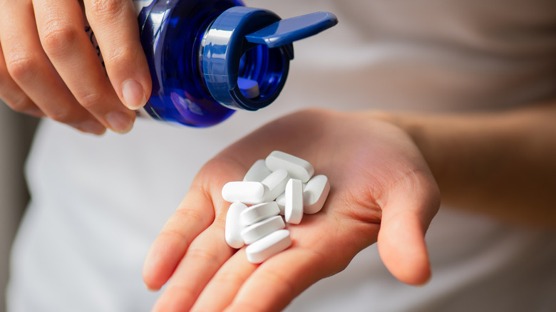hand holding calcium supplement pills