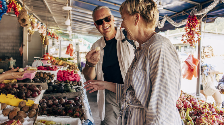 mature couple shopping for fruit in outdoor store