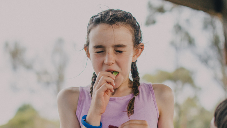 girl eating sour candy