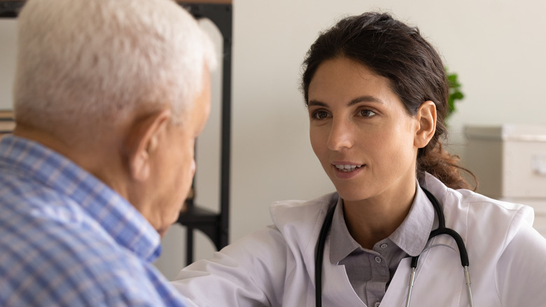 young doctor talking with elderly male