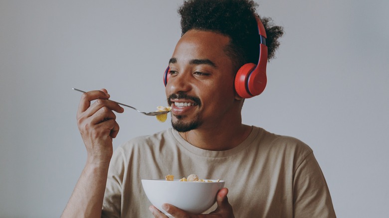 Man with headphones eating cereal