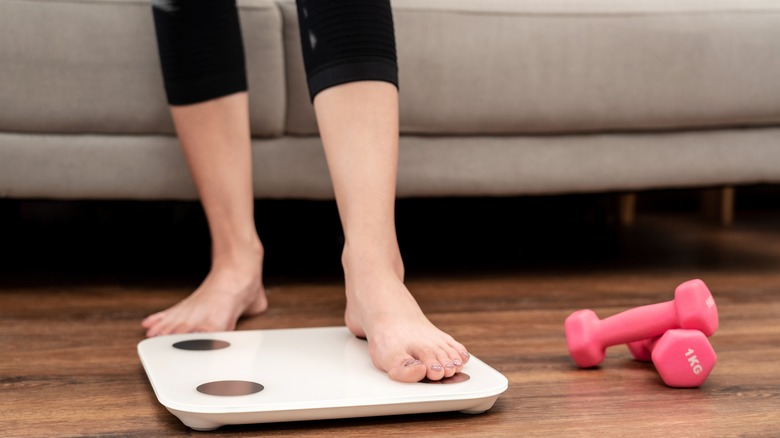 Woman stepping on a weight scale
