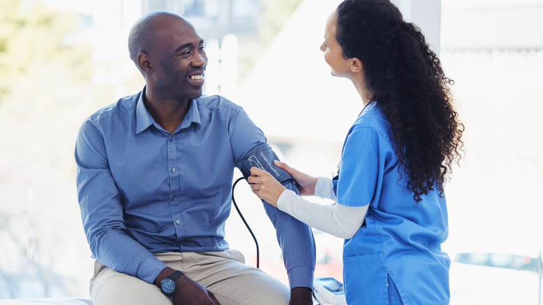 smiling man getting blood pressure reading