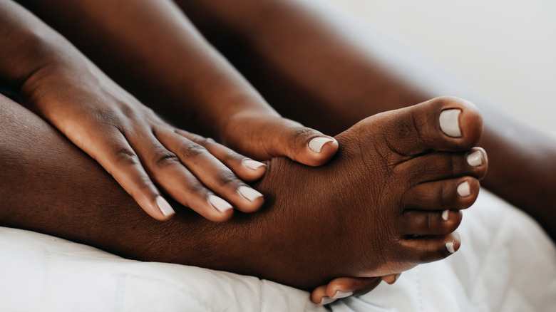 woman massaging foot and leg