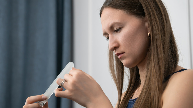 woman filing her fingernails