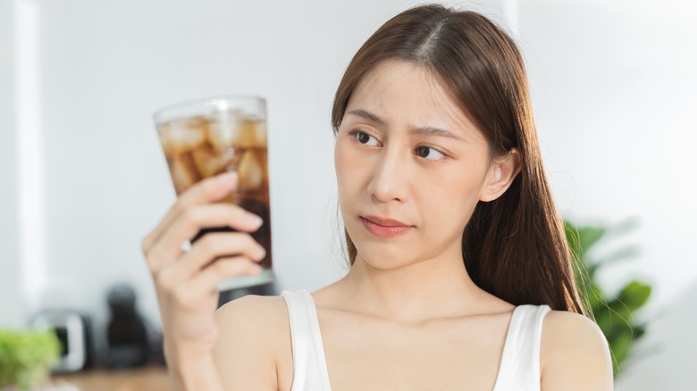 young woman holding glass of soda
