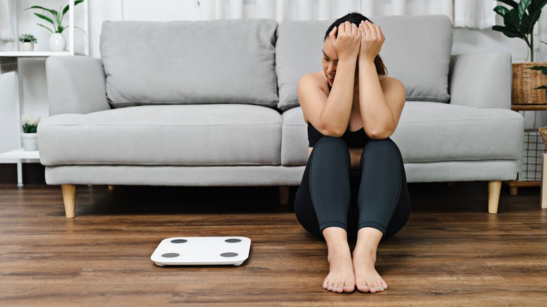 A woman is unhappy looking at the scale