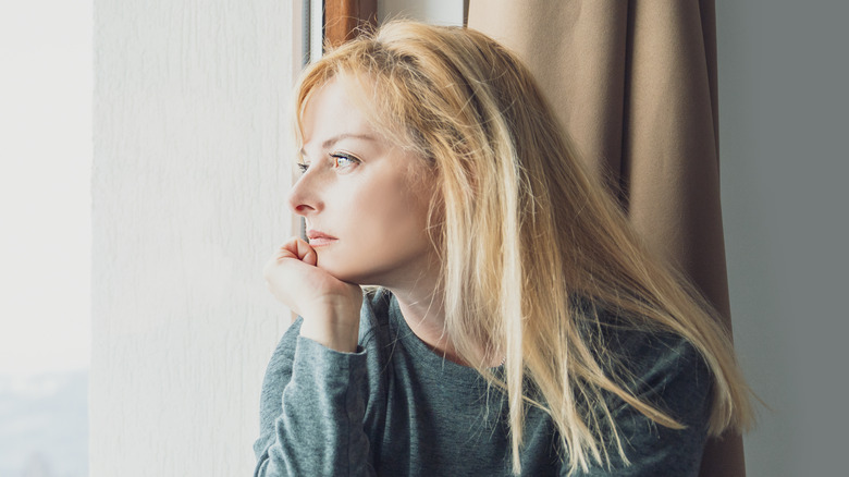 Blond woman looking out window