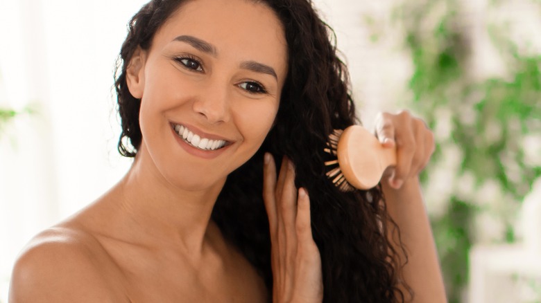 Smiling woman brushing hair