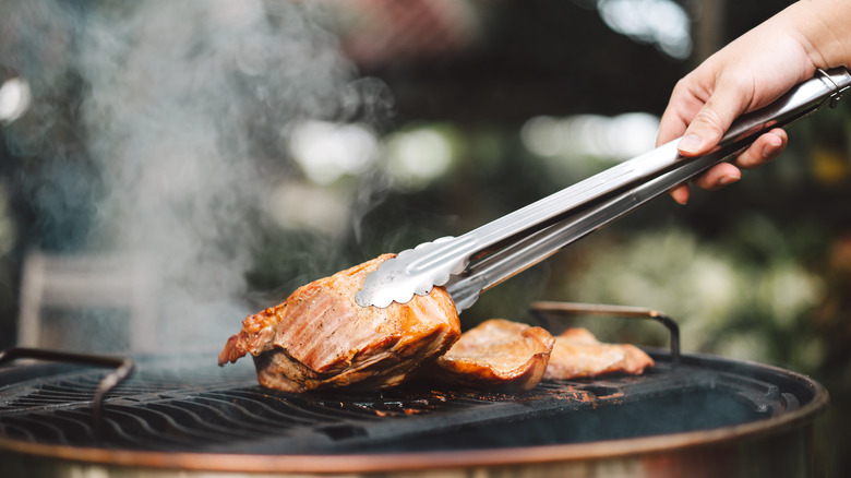 A man grills meat outside