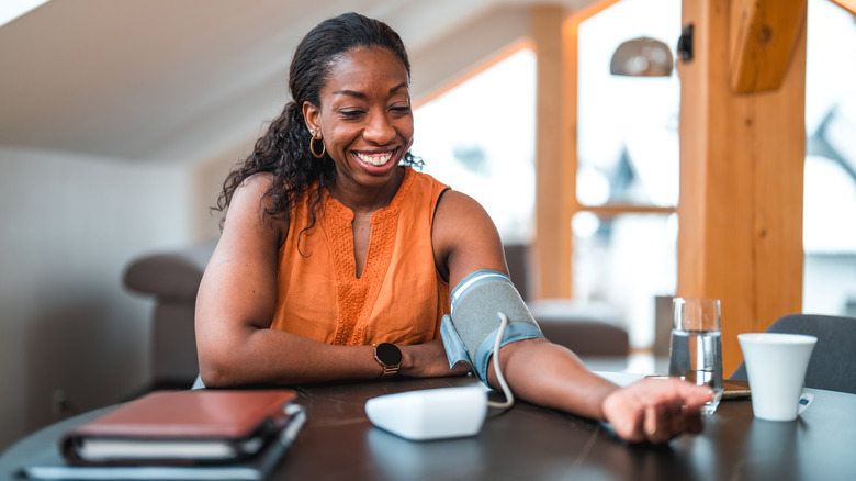 Smiling woman checking blood pressure