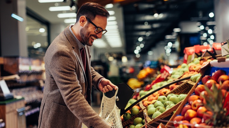 Smiling man shopping for fruit