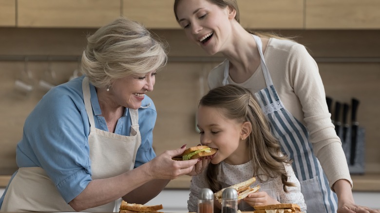 grandmother, mother, and daughter making sandwiches