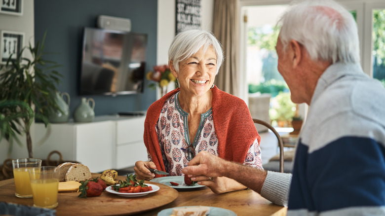 An elderly couple drinking juice with breakfast