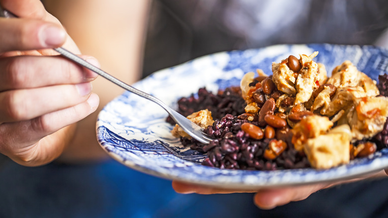 A plate of pinto and black beans with chicken