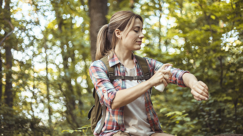 Woman applying mosquito repellent