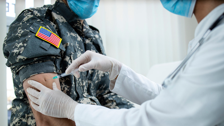 Healthcare worker vaccinating a soldier 