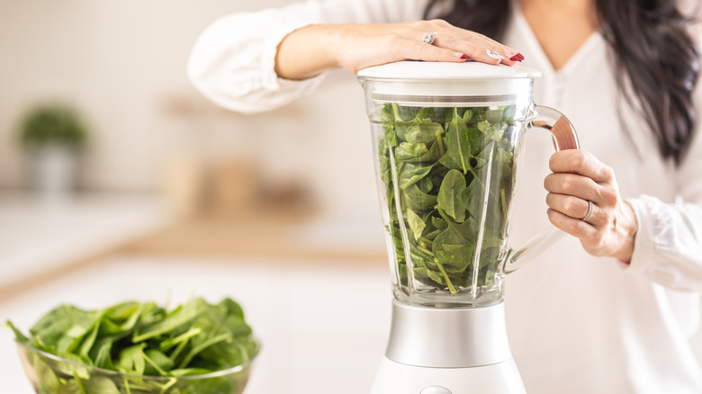A woman blending spinach