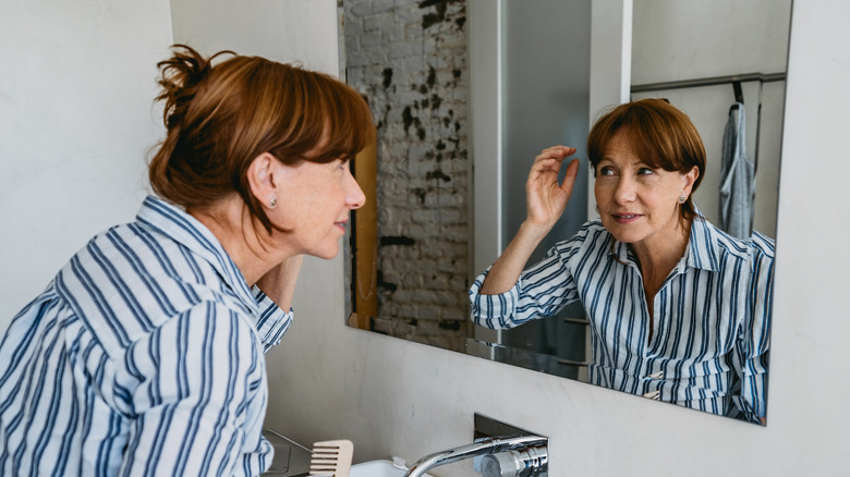 Woman looking at herself in mirror