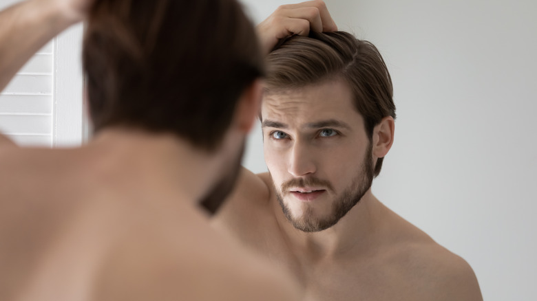 Man checking hair in mirror