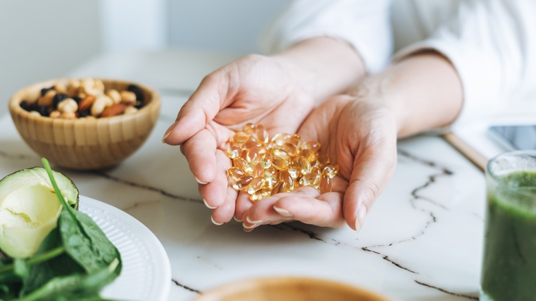 A doctor holds a handful of vitamins