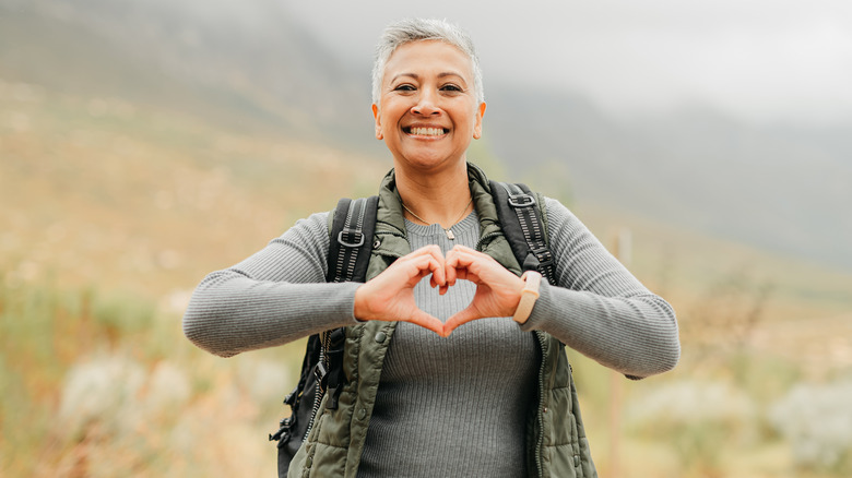 older woman making heart shape with her hands
