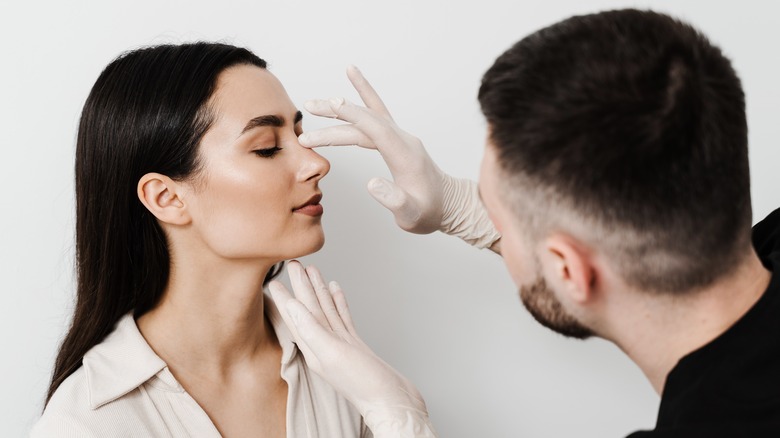 ENT doctor touching woman's nose
