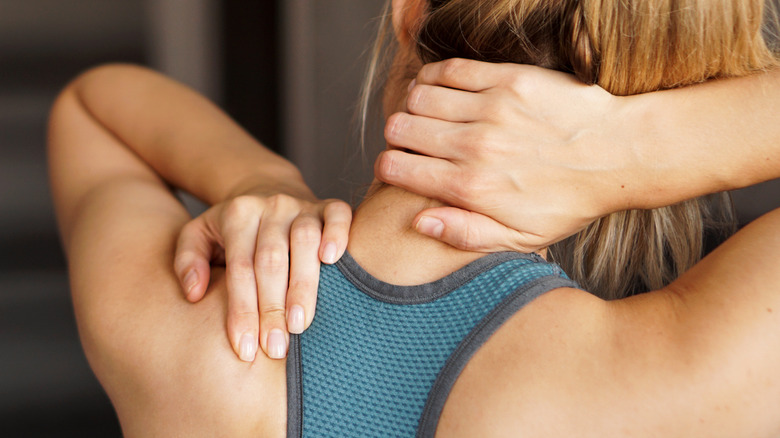 woman in pain holding shoulder