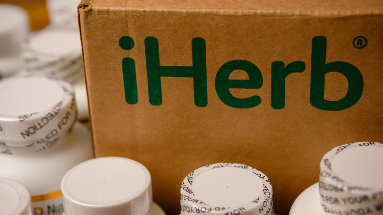 iHerb box surrounded by supplement bottles