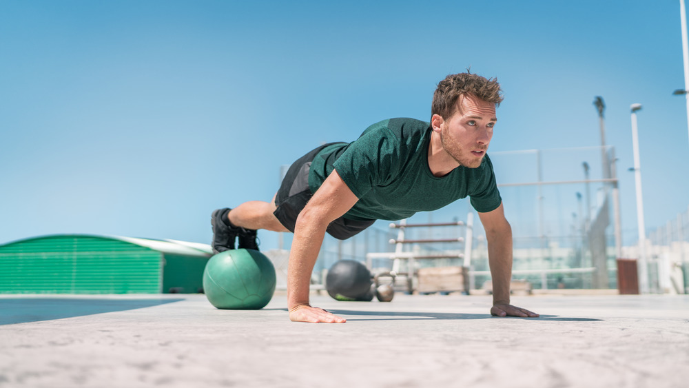 man doing pushups on stability ball